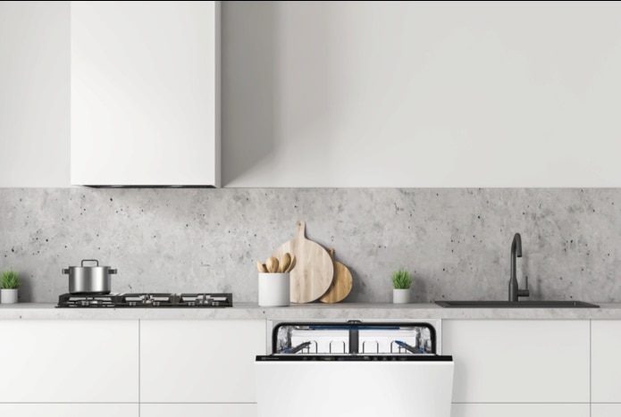 White minimalist kitchen with an open built-in dishwasher, gas hob and hood.